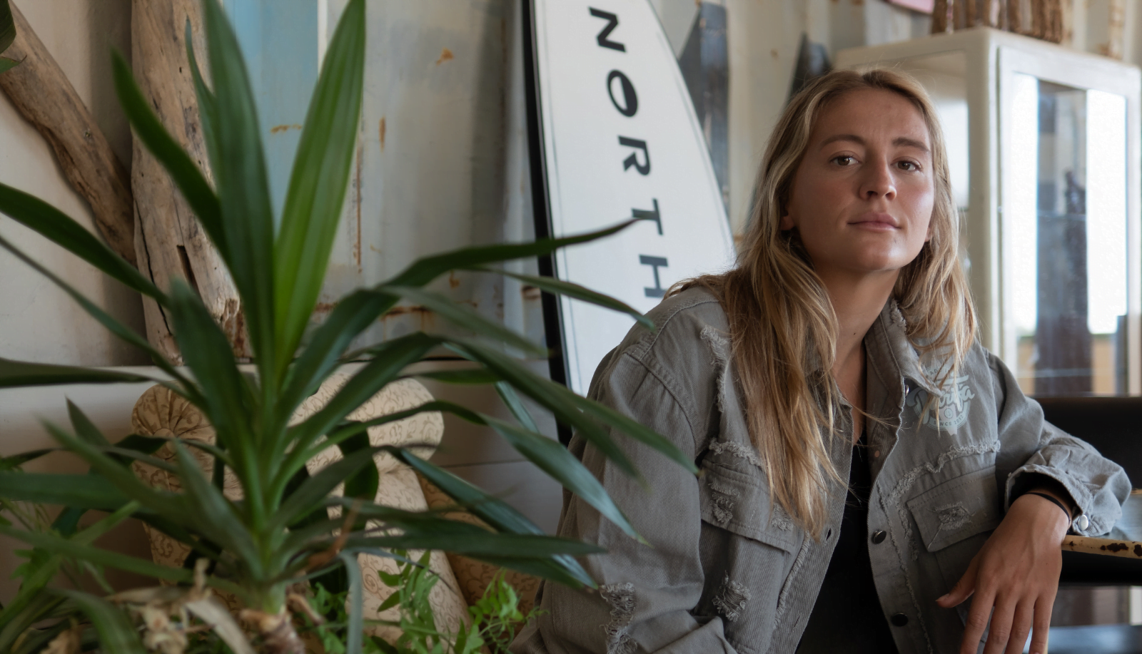 foto de la rider capucine Delannoy vistiendo cazadora de Made In Tarifa y posando con tabla de surf de north